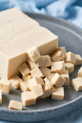 Tofu made with soybeans, sliced in cubes and served on a plate.