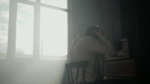 Secret agent listens on the reel tape recorder. Officer wiretapping in headphones. Spying of conversations. Intelligence gathering. Espionage concept. Report information to superiors.