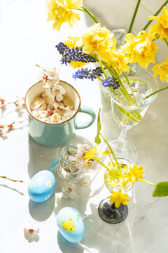 Easter concept. Various spring flowers and colored Easter eggs. Delicate light photo with soft artistic focus