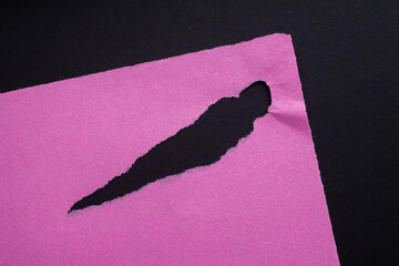 Pink torn paper texture background. Ripped paper on black background.