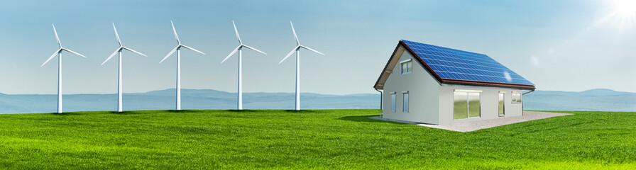 Windräder und Solarzellen auf einem Hausdach auf einer Grünen Wiese in einer hügeligen Landschaft