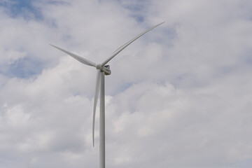 Wind farm with tall wind turbines to generate electricity. Green energy concept.