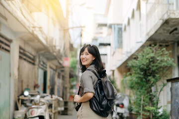Fototapeta na wymiar Young Asian woman backpack traveler enjoying street cultural local place and smile. Traveler checking out side streets.