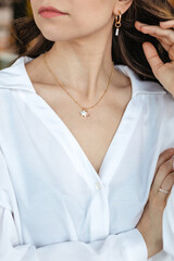 A woman in a white shirt adjusts her hair close-up