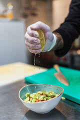 Close up shot of professional chef's hands working in restaurant kitchen. He prepares healthy delicious dish.