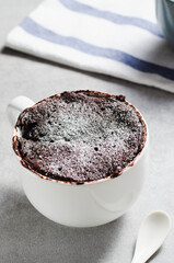 Chocolate Mug Cake, Homemade Cake Cooked in the Microwave on Bright Background
