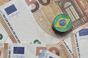euro coin with national flag of brazil on the euro money banknotes background