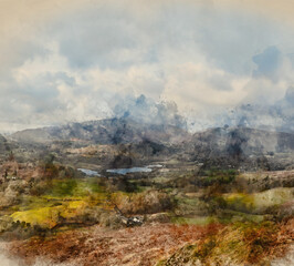 Stunning Winter sunrise golden hour landscape view from Loughrigg Fell across the countryside towards Langdale Pikes in the Lake District