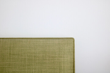 Soft furnishing background of green textured fabric on plain white background
