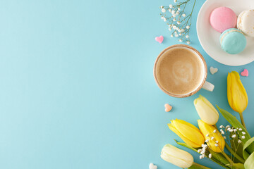 Mother's Day concept. Top view photo of cup of coffee plate with macaroons small hearts yellow white tulips and gypsophila flowers on pastel blue background with blank space