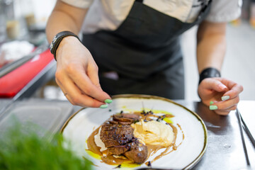Chef cooking Roasted Duck breast fillets with vegetable pure on restaurant kitchen