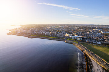 Aerial view on Salthill area of Galway city, Ireland. Warm sunny day. Popular educational center and tourist hub with vivid night life. Sun flare.