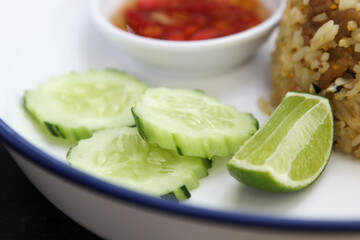 Fried rice with cucumber, lime and chilli fish sauce in white ceramic plate