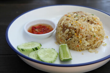 Fried rice with cucumber, lime and chilli fish sauce in white ceramic plate