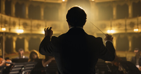 Back View Cinematic shot of Conductor Directing Symphony Orchestra with Performers Playing Violins, Cello and Trumpet on Classic Theatre with Curtain Stage During Music Concert - obrazy, fototapety, plakaty