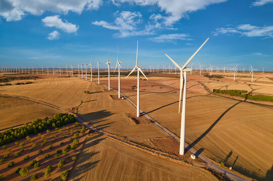 Aerial top view of a Wind turbines Farm with Wind turbines (group of objects) producing electricity natural energy at sunset. Numerous windmills turning in the background, Wind Energy, Spain
