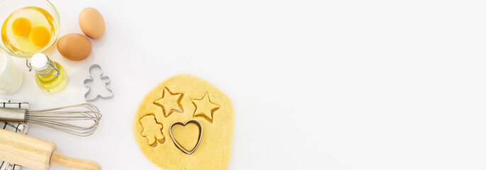 Christmas baking background with copy space for a greeting text, peace of dough rolled out for cooking Xmas gingerbreads, top down view. copy space banner