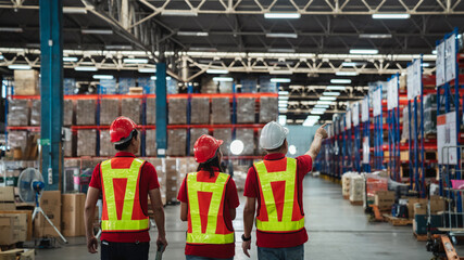 Warehouse workers walking to check details stock product in the background warehouse., Industrial...