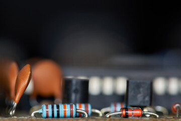 Detail of Resistors of a motherboard of an old computer with other components out of focus