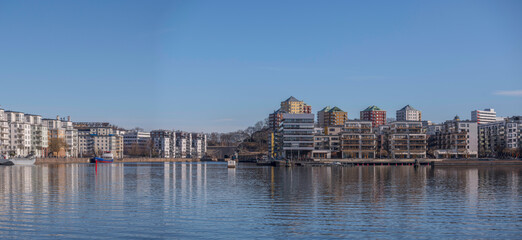 Fototapeta premium Waterfront apartment house and boats at a pier in the bay Hammarby sjö, a sunny spring day in Stockholm
