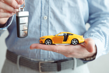 Businessman Holding a Car Key and Toy Car, Vehicle Dealer or Rent concept