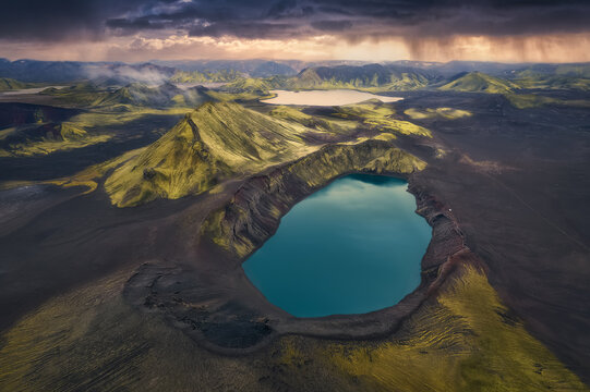 Aerial View of the storm coming to Blahylur (Hnausapollur) volcanic crater lake, the turquoise blue volcano in the south highlands of Iceland, Fjallabak Nature Reserve, Landmannalaugar, Iceland