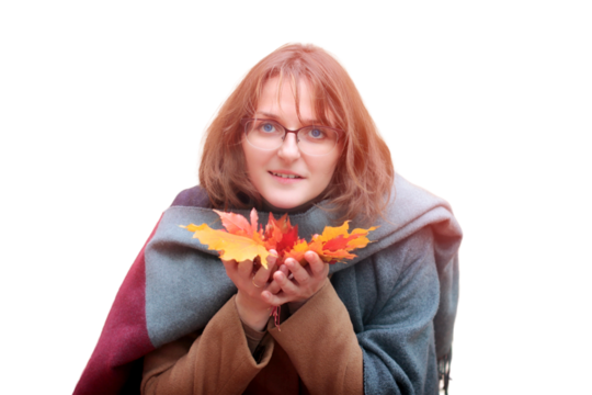 A young woman holding colored leaves, isolated on a white background. Woman in autumn coat and scarf with beautiful leaves on the palm.