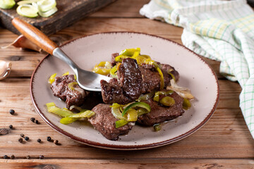 Meat medallions with leek. Pork medallions. Roasted fillet. Main course - Meat steak from pork on ceramic plate.