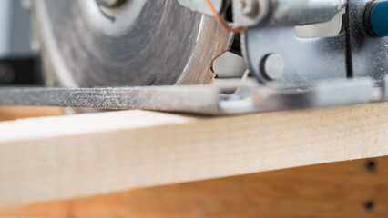 Carpenter cutting wood. Electric circular saw close up