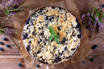 Cake with blueberry decorated with mint on wooden table. Breakfast morning table.