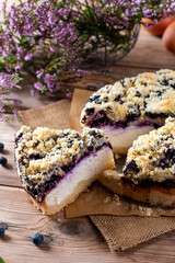 Piece of homemade blueberry cake with berries on wooden table , close up