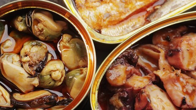 Spanish fish seafood Canned preserves food in tin open cans. sardines, squid, tuna, mussels in olive oil. Traditional Spanish supermarket food.