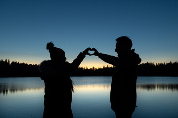 Silhouette de deux personnes et des mains en forme de coeur