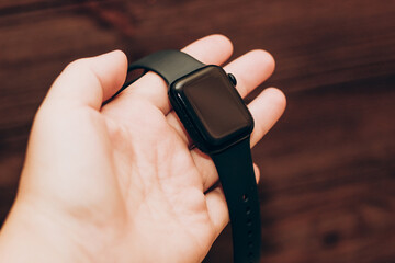 Black technological smart watch in hand.