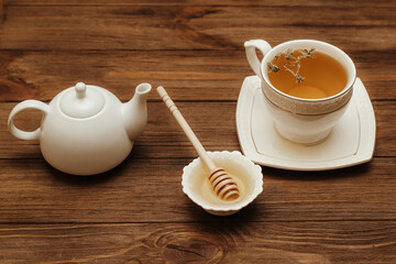 Liquid fresh linden honey in a plate with a wooden honey spoon and tea.