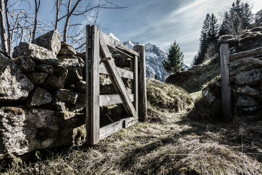 Ein offenes Holzgatter am Weg zu einer Alm