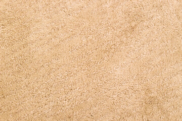 Fototapeta na wymiar The texture of the beige textile carpet.