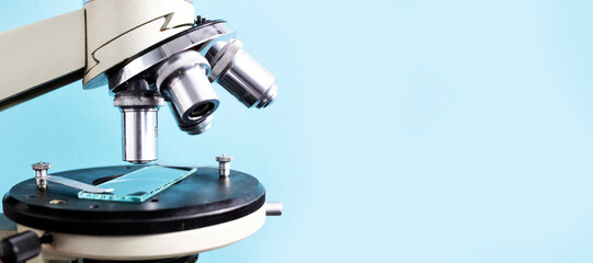 Microscope close-up on a blue background. Banner, Side view, place for text