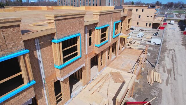 Aerial view of modern townhouse condominium building under construction in Canada, America. Wooden house with timber framing and cement basement, modern house design.