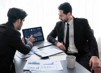 Busy analyst team discussing financial data on digital dashboard, analyzing chart and graph using...