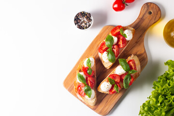 Tomato, basil and cheese fresh made caprese bruschetta. Italian tapas, antipasti with vegetables,...