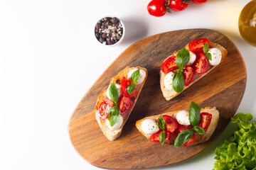 Tomato, basil and cheese fresh made caprese bruschetta. Italian tapas, antipasti with vegetables, herbs and oil on grilled ciabatta and baguette bread. Sandwich.