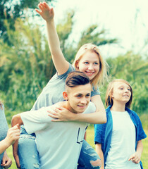 Fototapeta premium teenagers running through green lawn in summer in park