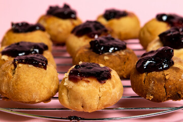 Cookies with plum jam filling on a metal rack