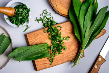 Wild garlic. Wild garlic on a wooden board on a grey table.