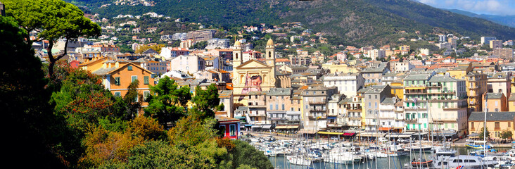 Obraz premium The old historic port of Bastia, in Corsica, located at the foot of the Citadel and dominated by the Saint Jean-Baptiste church has retained all the authenticity of its Mediterranean charm
