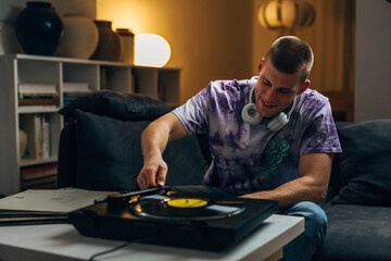 Fototapeta na wymiar An attractive man is listening to music using gramophone as a hobby