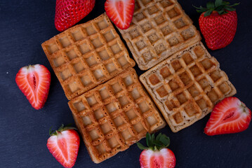 Belgian waffles with strawberries on a black background.