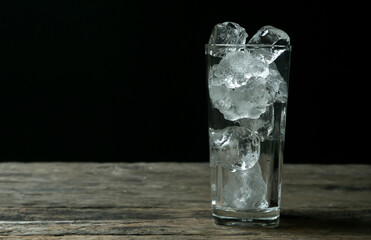 Glass with ice on wooden table