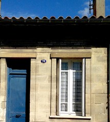 Small stone house with blue door in Bordeaux, France